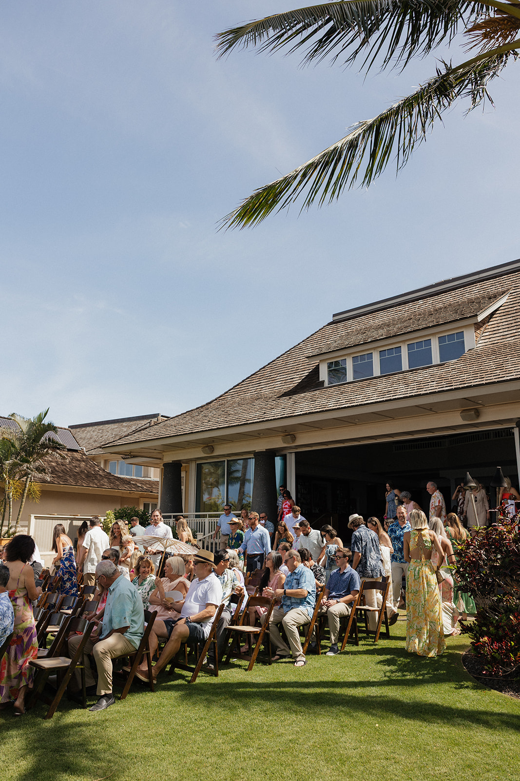 Wedding guests mingle and find their seats on the lawn in front of the reception venue before the ceremony begins.