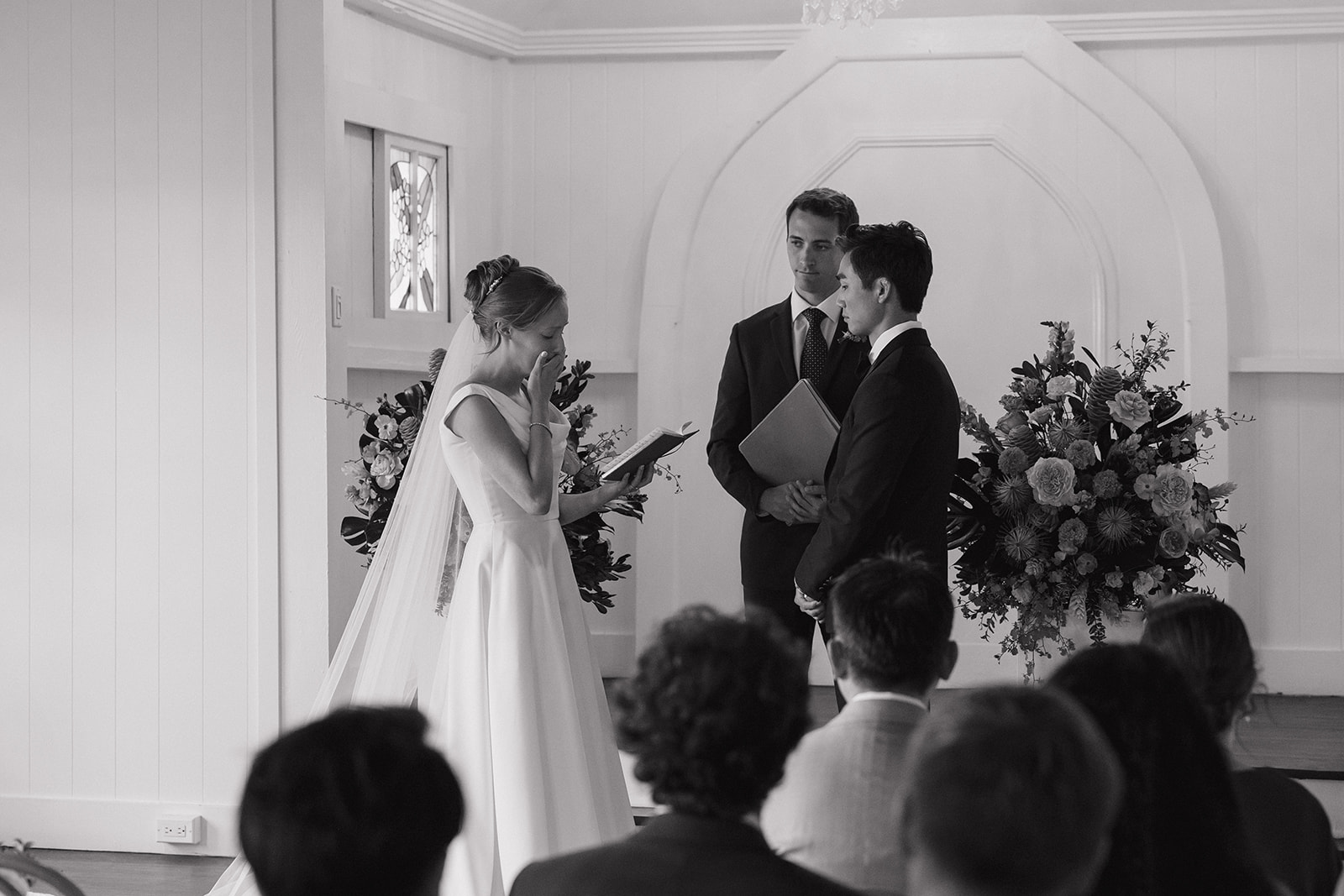 Black and white photo of a bride wiping happy tears while reading her vows during a Maui Pineapple Chapel ceremony.