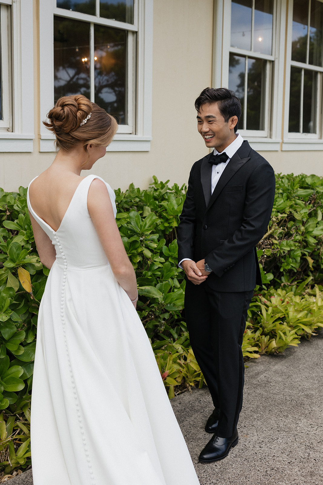 Groom smiling with happy anticipation during the first look with his bride outside the Maui Pineapple Chapel.